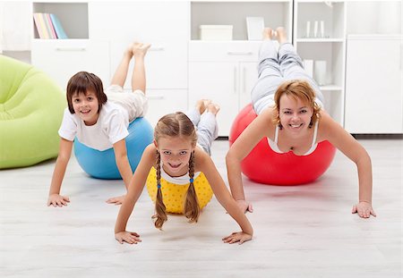 Happy people using large exercise balls - doing gymnastic at home Photographie de stock - Aubaine LD & Abonnement, Code: 400-06642101
