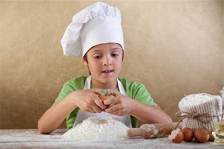 simsearch:400-04114221,k - Little chef preparing the dough for cookies - breaking an egg into the flour Stock Photo - Budget Royalty-Free & Subscription, Code: 400-06642118