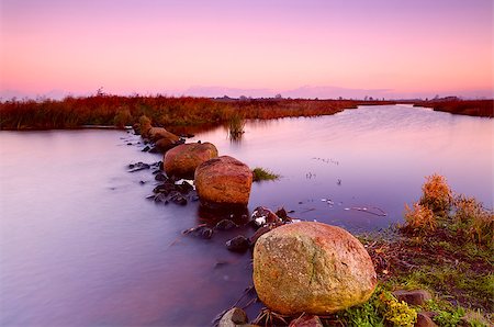 drenthe - big stones on wide river at colorful sunrise Foto de stock - Royalty-Free Super Valor e Assinatura, Número: 400-06643418