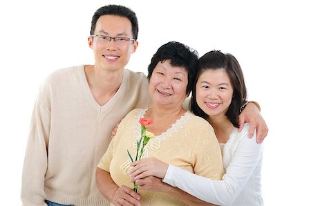 Asian family celebrates Mothers Day. Adult offspring giving carnation flowers to senior mother isolated on white. Stock Photo - Budget Royalty-Free & Subscription, Code: 400-06643505