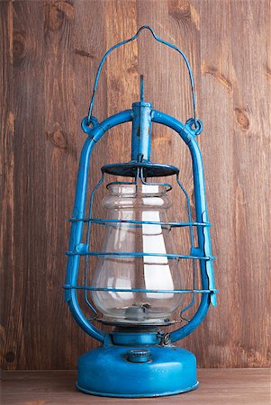 Old kerosene lantern on the dark wooden background Fotografie stock - Microstock e Abbonamento, Codice: 400-06643925