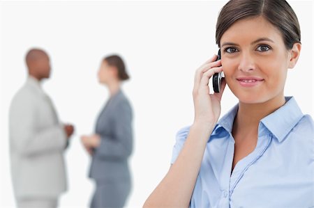 simsearch:400-06686555,k - Tradeswoman with mobile phone and associates behind her against a white background Stock Photo - Budget Royalty-Free & Subscription, Code: 400-06685346