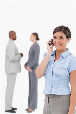 simsearch:400-06686562,k - Smiling saleswoman on the phone with associates behind her against a white background Foto de stock - Super Valor sin royalties y Suscripción, Código: 400-06685355