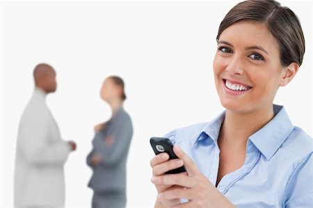 simsearch:400-06686562,k - Smiling saleswoman with mobile phone and associates behind her against a white background Foto de stock - Super Valor sin royalties y Suscripción, Código: 400-06685351