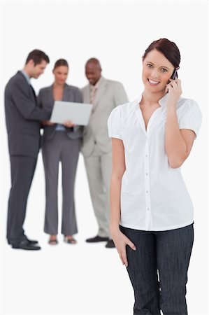 simsearch:400-06686555,k - Saleswoman with associates behind her on the phone against a white background Stock Photo - Budget Royalty-Free & Subscription, Code: 400-06685391