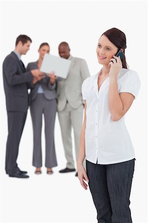 simsearch:400-06686562,k - Tradeswoman with colleagues behind her on the phone against a white background Foto de stock - Super Valor sin royalties y Suscripción, Código: 400-06685392