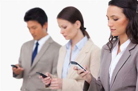 simsearch:400-06686555,k - Businessteam looking at their cellphones against a white background Stock Photo - Budget Royalty-Free & Subscription, Code: 400-06685519