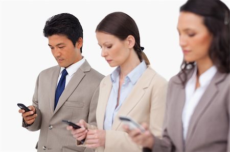 simsearch:400-06686555,k - Young businessteam with their cellphones against a white background Stock Photo - Budget Royalty-Free & Subscription, Code: 400-06685521
