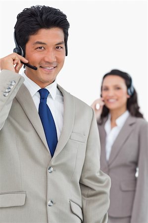 simsearch:400-06108986,k - Smiling customer support employee with colleague behind him against a white background Stock Photo - Budget Royalty-Free & Subscription, Code: 400-06685614