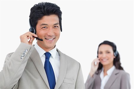 simsearch:400-06108986,k - Smiling call center agent with colleague behind him against a white background Stock Photo - Budget Royalty-Free & Subscription, Code: 400-06685611