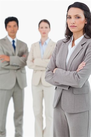 simsearch:400-07186359,k - Tradeswoman with arms folded and colleagues behind her against a white background Stock Photo - Budget Royalty-Free & Subscription, Code: 400-06685630