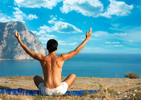 Young Man in Lotus Position near the Ocean. Rear View Stock Photo - Budget Royalty-Free & Subscription, Code: 400-06685815