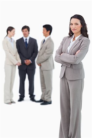 simsearch:400-07186359,k - Serious saleswoman with arms crossed and team behind her against a white background Stock Photo - Budget Royalty-Free & Subscription, Code: 400-06686478