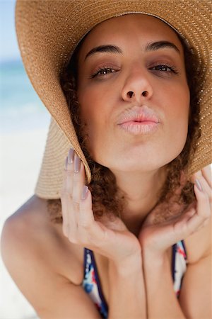 simsearch:6109-06195272,k - Young woman wearing a straw hat while puckering her lips in front of the sea Foto de stock - Super Valor sin royalties y Suscripción, Código: 400-06686965