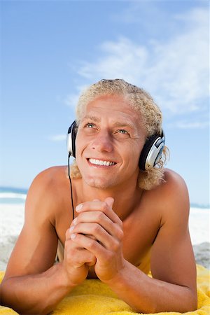 Smiling man crossing his hands while listening to music with his headset Stock Photo - Budget Royalty-Free & Subscription, Code: 400-06687003