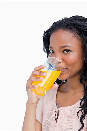 simsearch:400-06636885,k - A young girl is looking at the camera and drinking orange juice Photographie de stock - Aubaine LD & Abonnement, Code: 400-06687197