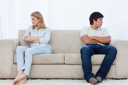 simsearch:400-06687238,k - A angry couple sit at the two ends of the couch with their arms folded looking away Fotografie stock - Microstock e Abbonamento, Codice: 400-06687238