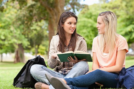 Female teenagers sitting while studying with a textbook in a park Stock Photo - Budget Royalty-Free & Subscription, Code: 400-06688002