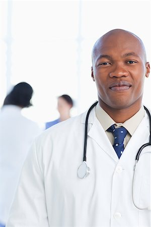Young doctor grinning in front of his medical team with a confident look on his face Stock Photo - Budget Royalty-Free & Subscription, Code: 400-06688527