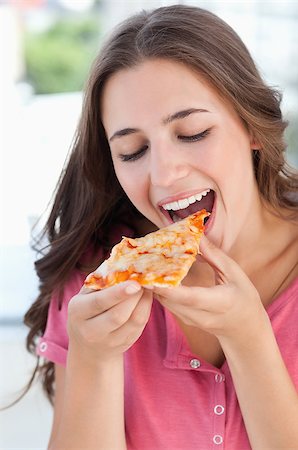 eat mouth closeup - A woman holding a piece of pizza to her mouth as she is about to eat Stock Photo - Budget Royalty-Free & Subscription, Code: 400-06688541
