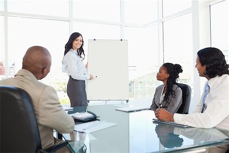 Young businesswoman giving a presentation while her colleagues are listening to her Stock Photo - Budget Royalty-Free & Subscription, Code: 400-06688578
