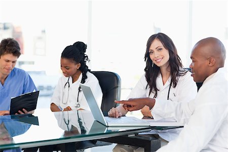 Smiling medical interns working on the computer near co-workers Stock Photo - Budget Royalty-Free & Subscription, Code: 400-06688616