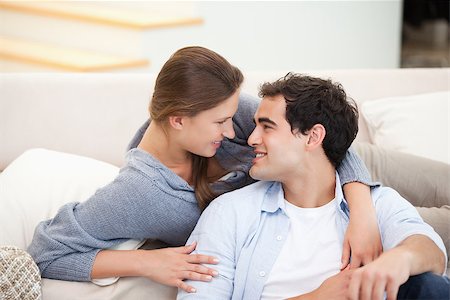 Couple embracing eachother while sitting a sofa in a sitting room Stock Photo - Budget Royalty-Free & Subscription, Code: 400-06689087