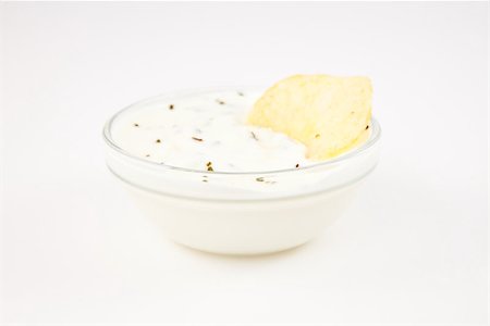 simsearch:400-06689258,k - Bowl of dip with herbs with a chip dipped in it against a white background Stock Photo - Budget Royalty-Free & Subscription, Code: 400-06689290