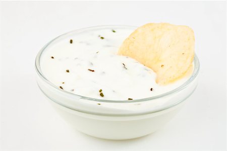 simsearch:400-06689258,k - Bowl of white dip with herbs and a nacho dipped in it against a white background Stock Photo - Budget Royalty-Free & Subscription, Code: 400-06689292