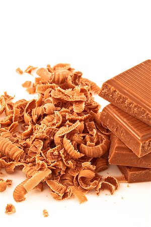 Many chocolate shavings beside a pile of chocolate against a white background Stock Photo - Budget Royalty-Free & Subscription, Code: 400-06689391