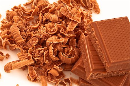 Chocolate shavings surrounding a pile of chocolate against a white background Stock Photo - Budget Royalty-Free & Subscription, Code: 400-06689393
