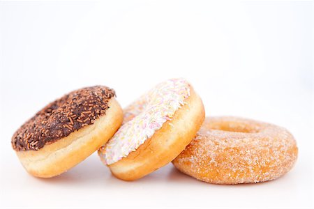 doughnut background - Three doughnuts with icing sugar lined up against a white background Stock Photo - Budget Royalty-Free & Subscription, Code: 400-06689524