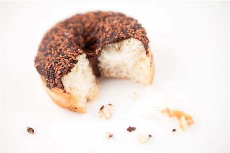 doughnut background - Chocolate doughnut with crumbs against grey background Stock Photo - Budget Royalty-Free & Subscription, Code: 400-06689579