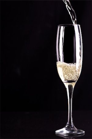 simsearch:400-06689258,k - Glass of champaigne being filled against black background Stock Photo - Budget Royalty-Free & Subscription, Code: 400-06689618