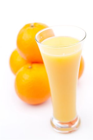 simsearch:400-06689686,k - Oranges behind a glass of orange juice against white background Foto de stock - Super Valor sin royalties y Suscripción, Código: 400-06689652