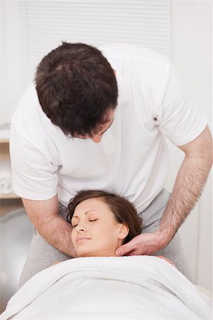 Therapist massaging the neck of a woman while holding her head in a room Stock Photo - Budget Royalty-Free & Subscription, Code: 400-06689840