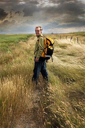 simsearch:400-08750109,k - Man looking back and smiling on a prairie country road Foto de stock - Super Valor sin royalties y Suscripción, Código: 400-06695275