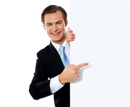 simsearch:400-06695536,k - Young smiling business person pointing towards blank signboard Stock Photo - Budget Royalty-Free & Subscription, Code: 400-06695509