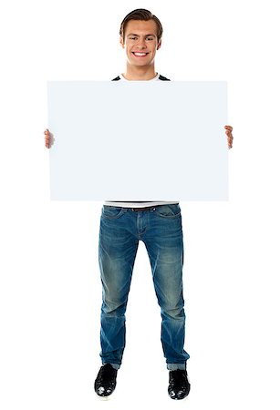 simsearch:400-06695536,k - Full length view of happy smiling young man showing blank signboard Stock Photo - Budget Royalty-Free & Subscription, Code: 400-06695534