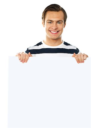 simsearch:400-06695536,k - Casual young man holding a blank poster against white background Stock Photo - Budget Royalty-Free & Subscription, Code: 400-06695531