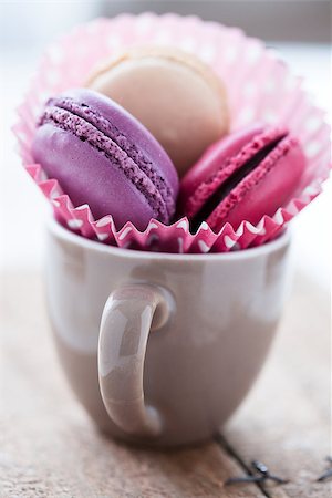 Closeup of three different flavoured macaroons in cup on wooden table Stock Photo - Budget Royalty-Free & Subscription, Code: 400-06697364