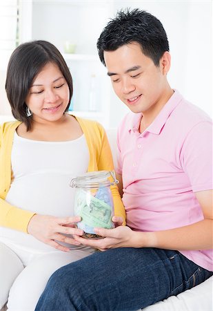 Asian family financial planning concept. Young pregnant couple saving money for future. Living lifestyle at home. Stock Photo - Budget Royalty-Free & Subscription, Code: 400-06698013