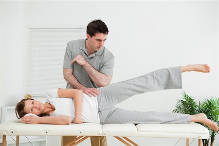 female pelvis - Doctor pressing his elbow on her hip while woman raising her leg in a room Stock Photo - Budget Royalty-Free & Subscription, Code: 400-06690036