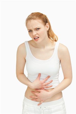 simsearch:400-06690149,k - Woman placing her hands on her painful stomach against white background Stock Photo - Budget Royalty-Free & Subscription, Code: 400-06690134