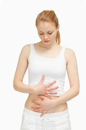 simsearch:400-06690149,k - Woman placing her hands on her stomach against white background Stock Photo - Budget Royalty-Free & Subscription, Code: 400-06690133