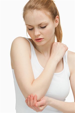 simsearch:400-06690149,k - Woman touching her elbow against white background Stock Photo - Budget Royalty-Free & Subscription, Code: 400-06690149