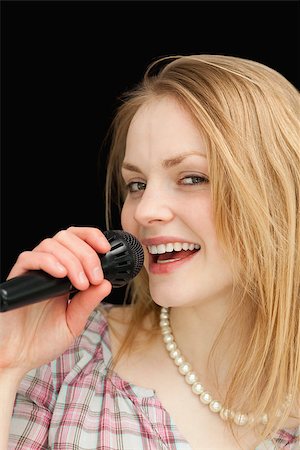 Fair-haired woman singing against black background Stock Photo - Budget Royalty-Free & Subscription, Code: 400-06690156