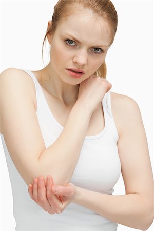 simsearch:400-06690149,k - Blonde woman touching her elbow against white background Stock Photo - Budget Royalty-Free & Subscription, Code: 400-06690150
