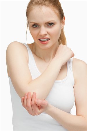 simsearch:400-06690149,k - Blonde woman touching her painful elbow against white background Stock Photo - Budget Royalty-Free & Subscription, Code: 400-06690151