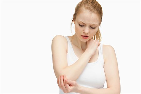 simsearch:400-06690149,k - Young woman touching her elbow against white background Stock Photo - Budget Royalty-Free & Subscription, Code: 400-06690152